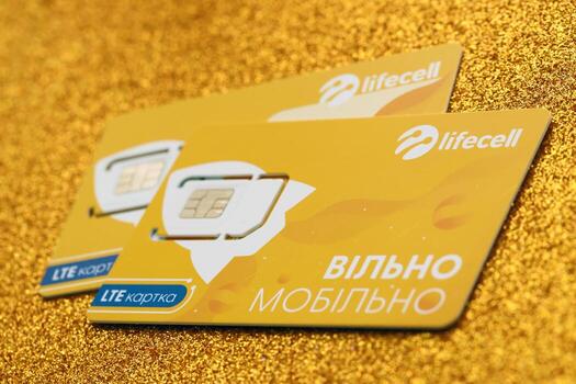 TERNOPIL, UKRAINE - JULY 5, 2022 Lifecell new sim card with free contract on yellow background. Lifecell is ukrainian mobile telephone network operator and provider of wireless connection photo