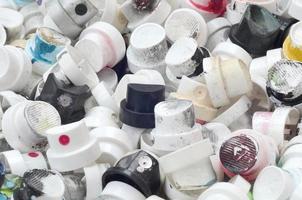 A pattern of many used and soiled nozzles from spray cans with aerosol paint. Background texture of the street art of drawing graffiti on the walls photo