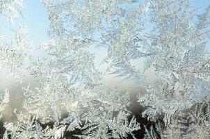 Snowflakes frost rime macro on window glass pane photo