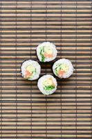 Sushi rolls lies on a bamboo straw serwing mat. Traditional Asian food. Top view. Flat lay minimalism shot with copy space