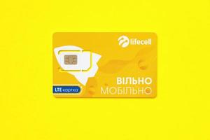 TERNOPIL, UKRAINE - JULY 5, 2022 Lifecell new sim card with free contract on yellow background. Lifecell is ukrainian mobile telephone network operator and provider of wireless connection photo