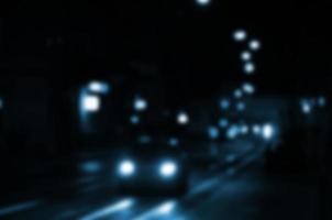 escena nocturna borrosa de tráfico en la carretera. imagen desenfocada de coches que viajan con faros luminosos. arte bokeh foto