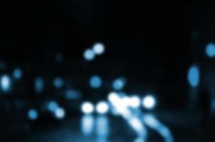 Blurred night scene of traffic on the roadway. Defocused image of cars traveling with luminous headlights. Bokeh Art photo
