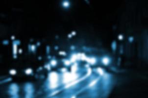 Blurred night scene of traffic on the roadway. Defocused image of cars traveling with luminous headlights. Bokeh Art photo