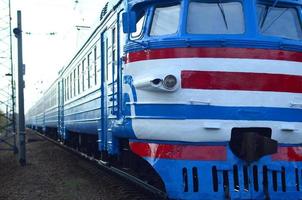 Old soviet electric train with outdated design moving by rail photo