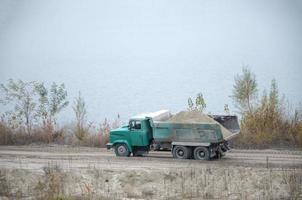 Dump truck transports sand and other minerals in the mining quarry. Heavy industry photo