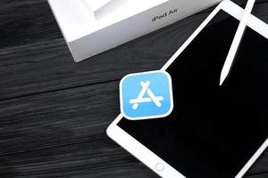 kharkiv, ucrania - 27 de enero de 2022 nuevo ipad de apple y lápiz de apple y logotipo azul de la tienda de aplicaciones sobre fondo negro. Apple Inc. es una empresa de tecnología americana foto