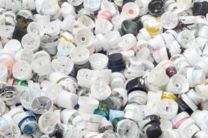 A pattern of many used and soiled nozzles from spray cans with aerosol paint. Background texture of the street art of drawing graffiti on the walls photo