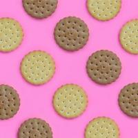 Pattern of a brown biscuits on a pink background. Trendy minimal concept of food and dessert. Abstract flat lay, top view photo