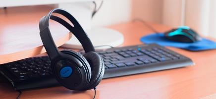 Big black headphones lie on the wooden desktop of the sound designer photo