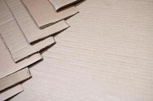 imagen de fondo con mucho papel cartón beige, que se utiliza para hacer cajas para el transporte de electrodomésticos y paquetes postales. textura de cartón foto