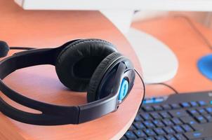 Big black headphones lie on the wooden desktop of the sound designer photo