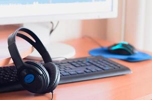 Big black headphones lie on the wooden desktop of the sound designer photo