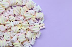 Colorful marshmallow laid out on violet paper background. pastel creative texture. minimal photo