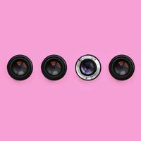 A few camera lenses with a closed aperture lie on texture background of fashion pastel pink color paper in minimal concept. Abstract trendy pattern photo