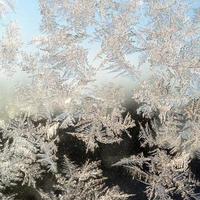 Snowflakes frost rime macro on window glass pane photo