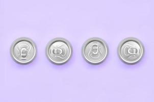 Many metallic beer cans on texture background of fashion pastel violet color paper in minimal concept photo