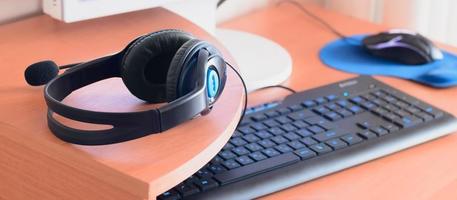 Big black headphones lie on the wooden desktop of the sound designer photo