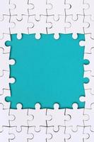 Framing in the form of a rectangle, made of a white jigsaw puzzle around the blue space photo