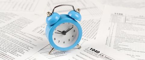 1040 Individual income tax return form and blue alarm clock photo
