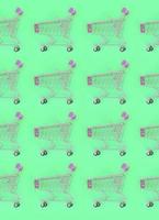 Shopping addiction, shopping lover or shopaholic concept. Many small empty shopping carts perform a pattern on a pastel colored paper background. Flat lay composition, top view photo