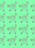 Shopping addiction, shopping lover or shopaholic concept. Many small empty shopping carts perform a pattern on a pastel colored paper background. Flat lay composition, top view photo