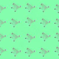 Shopping addiction, shopping lover or shopaholic concept. Many small empty shopping carts perform a pattern on a pastel colored paper background. Flat lay composition, top view photo