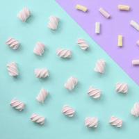 Colorful marshmallow laid out on violet and blue paper background. pastel creative textured pattern. minimal photo