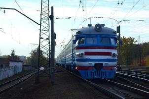 Old soviet electric train with outdated design moving by rail photo