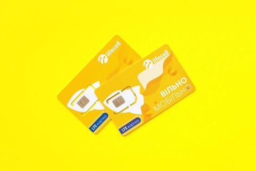 TERNOPIL, UKRAINE - JULY 5, 2022 Lifecell new sim card with free contract on yellow background. Lifecell is ukrainian mobile telephone network operator and provider of wireless connection photo