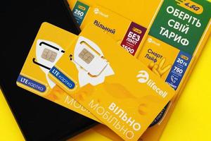 ternopil, ucrania - 5 de julio de 2022 nueva tarjeta sim lifecell con contrato gratuito sobre fondo amarillo. Lifecell es un operador ucraniano de red de telefonía móvil y proveedor de conexión inalámbrica foto