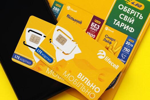 TERNOPIL, UKRAINE - JULY 5, 2022 Lifecell new sim card with free contract on yellow background. Lifecell is ukrainian mobile telephone network operator and provider of wireless connection photo