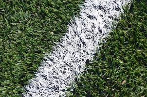 raya blanca en un campo de fútbol de césped artificial verde brillante foto