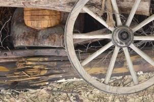 la vieja rueda de madera del carruaje cuelga en la pared del granero ucraniano foto