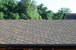 Modern roofing and decoration of chimneys. Flexible bitumen or slate shingles photo