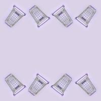 Pattern of many small shopping carts on a violet background. Minimalism flat lay top view photo
