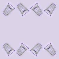 Pattern of many small shopping carts on a violet background. Minimalism flat lay top view photo