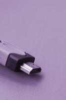 Black audio video HDMI computer cable on purple backdrop. Close up of home entertainment connection cable for sound and video photo