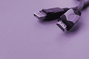 Audio video HDMI computer cable plug and 20-pin male DisplayPort gold plated connector for a flawless connection on purple backdrop photo