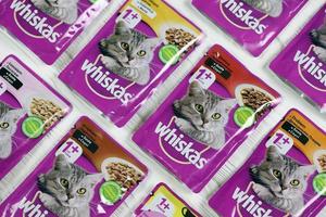 KHARKIV, UKRAINE - FEBRUARY 06, 2022 Whiskas branded cat pet food purple packages close up. Whiskas is a global brand of cat food produced by the American company Mars photo