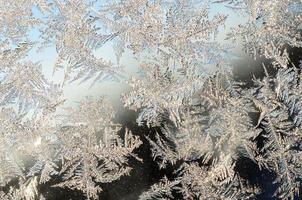 Snowflakes frost rime macro on window glass pane photo