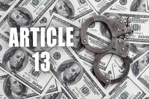 Police handcuffs and dollar bills with article 13 inscription photo