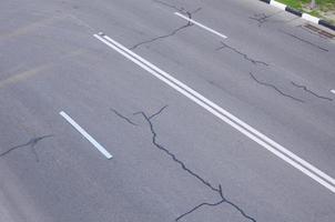 mal camino asfaltado dañado con baches. reparación de parches de asfalto foto