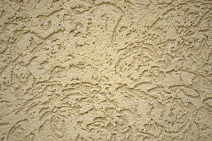 The texture of the beige decorative plaster in bark beetle style