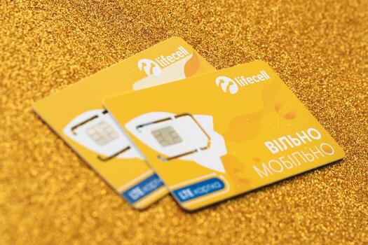 TERNOPIL, UKRAINE - JULY 5, 2022 Lifecell new sim card with free contract on yellow background. Lifecell is ukrainian mobile telephone network operator and provider of wireless connection photo