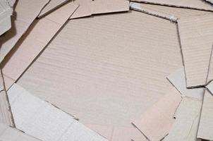 imagen de fondo con mucho papel cartón beige, que se utiliza para hacer cajas para el transporte de electrodomésticos y paquetes postales. textura de cartón foto