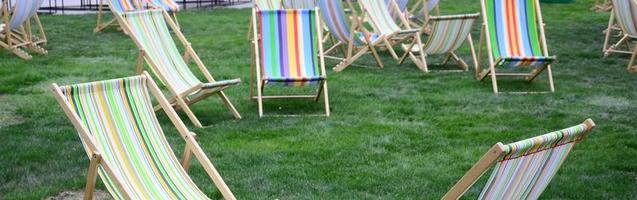 Chaise lounges on a lawn. Garden sunbeds on green grass photo