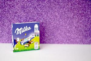 TERNOPIL, UKRAINE - JUNE 3, 2022 Milka milkinis small pack with chocolate finger bars. Milka is a Swiss brand of chocolate confection manufactured by company Mondelez International photo