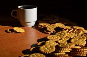 taza de café pequeña y galleta salada foto