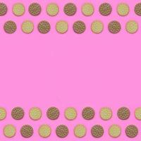 Frame of a brown biscuits on a pink background. Trendy minimal concept of food and dessert. Abstract flat lay, top view photo